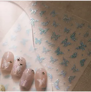 Vue macro de stickers 3D papillon bleu laser pour ongles avec fini pailleté métallique