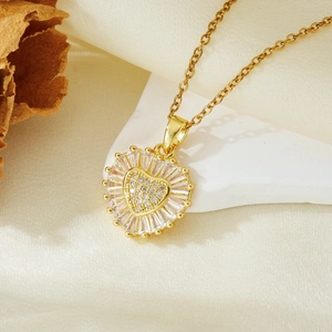 Macro detail of a gold heart pendant necklace with zircon inlay on a stone background