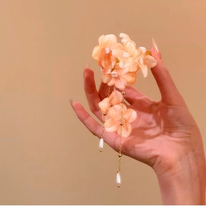 Detailed view of a sweet floral hair clip featuring pearl tassels and fabric flowers