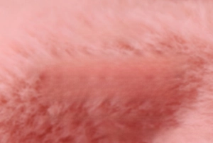 Close-up of thickened pink faux rabbit fur fabric with soft plush texture for heat bag