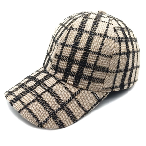 Dettaglio del cappellino da baseball in tweed a scacchi beige con fili d'oro scintillanti