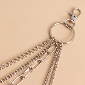 Detailed close-up of layered silver metal waist chain with heart charms and lobster clasp