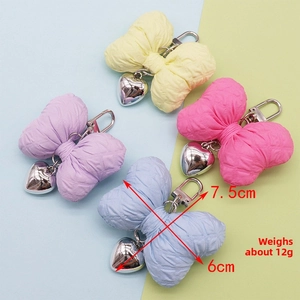 Detailed view of colorful quilted bow charms with silver heart pendants in four colors