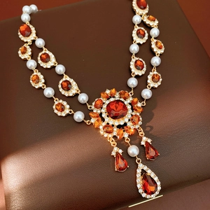 Detaillierte Nahaufnahme der Vintage-Goldkette mit Perlen und orangen Edelsteinen