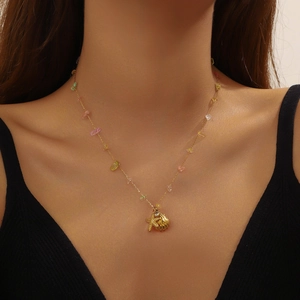 Gold starfish and shell pendant necklace with colorful beads on a female model