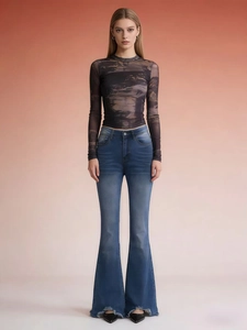 Women's flare jeans with frayed hems and mesh printed top on warm background