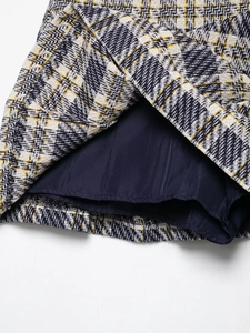 Détail du short-jupe à carreaux montrant le tissu en tweed bleu et blanc avec doublure