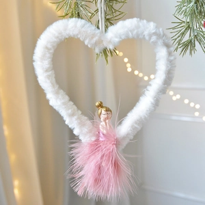 Plush heart Christmas ornament with pink feather fairy doll hanging on a tree with lights
