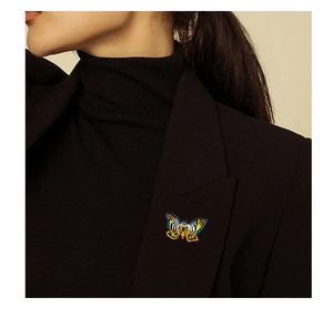Detailed close-up of colorful enamel butterfly brooch on a black suit lapel