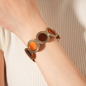 Detailed view of an antique gold elastic bracelet with leopard print resin on wrist