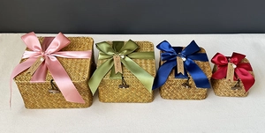 Set of four woven grass gift baskets with colorful satin bows and Thank You tags