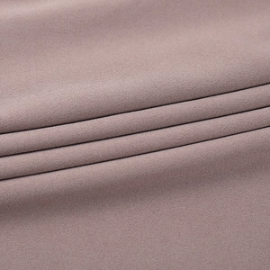 Detailed macro view of high-quality dusty pink knitted fabric with soft texture and drape