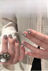 Detailed view of silver glitter press-on nails decorated with sparkling rhinestones