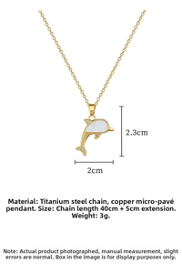 Close-up of golden dolphin pendant with white shell inlay and sparkling crystals