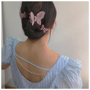 Close-up of pink butterfly hair clips in matte finish on a model for hair styling