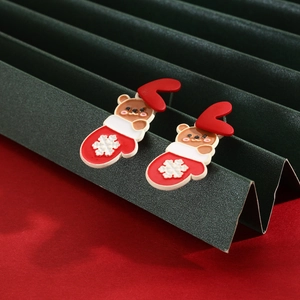 Detail of Christmas stud earrings featuring cartoon bear, red antler and snowflake glove