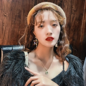 Close-up of a model wearing colorful star-shaped earrings and a gold pendant necklace