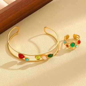Detail of gold jewelry set with colorful cabochon stones in a bohemian vintage style