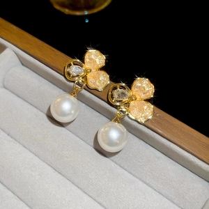 Détail de boucles d'oreilles vintage avec perles et zircons sur velours gris élégant