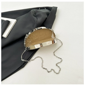 Macro shot of silver crescent evening bag showing brown suede lining and metal chain