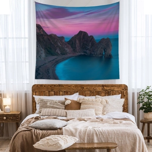 Bohemian sunset seascape wall tapestry in a cozy minimalist bedroom setting