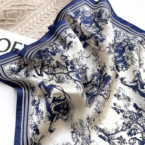 Detail of blue and white Toile de Jouy silk scarf featuring pastoral tree and animal patterns