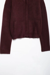 Vue détaillée du cardigan en maille bordeaux avec poches avant et texture côtelée