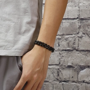 Close-up of men's chunky black Cuban link chain bracelet on a male model's wrist