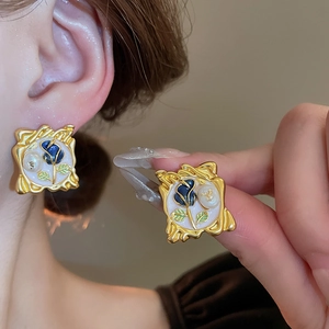 Detailed close-up of French vintage gold square frame earrings with blue rose and pearl