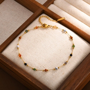 Close-up of golden anklet with colorful natural stone beads and S.STEEL hallmark