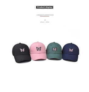 Vue détaillée de quatre casquettes en coton avec broderie papillon rose en diverses couleurs