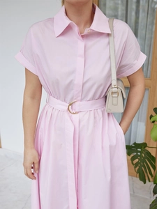 Detail of pink cotton shirt dress showing gold half-moon buckle and waist belt detail