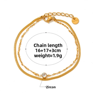 Detailed shot of double-layer gold snake chain bracelet with sparkling zircon stones