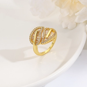 Luxe gold leaf open ring with sparkling cubic zirconia on a white ceramic display