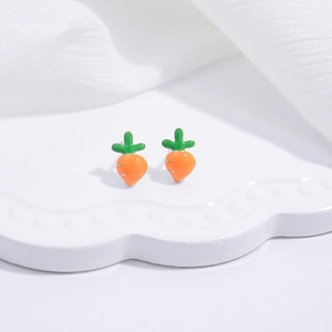 Detail of cute S925 silver carrot stud earrings on a wavy white display tray