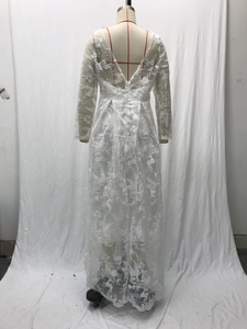 Detailed view of the V-shaped backless design and floral lace embroidery on the white bridal gown