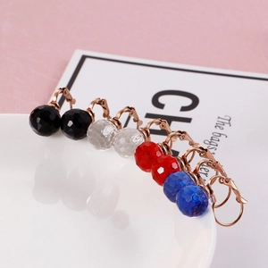 Detail of 10mm faceted crystal earrings in gold finish featuring four vibrant colors