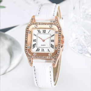 Detail of rose gold square watch case with crystal bezel and white leather strap