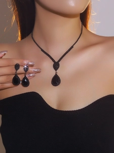 Detailed view of luxury black teardrop rhinestone necklace and earrings set on a model