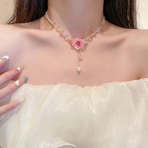 Detail of pink flower necklace with crystal beads and teardrop pearl on model neck