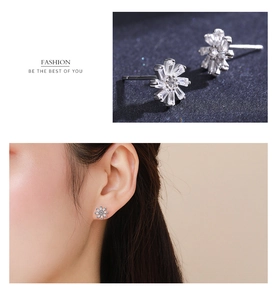 Macro view of S925 silver snowflake earrings with cubic zirconia on an Asian model