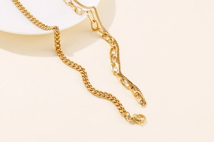 Detail of gold titanium steel necklace featuring a mixed Cuban and paperclip chain design