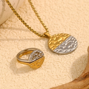 Close-up of two-tone hammered gold and silver necklace with open ring jewelry set