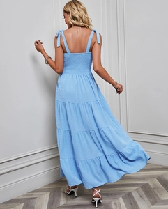 Détail du dos smocké et des bretelles nouées sur la robe longue à pois bleu clair à volants