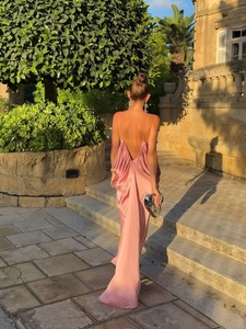 Dettaglio dell'abito lungo in raso rosa con schiena scoperta e spalline sottili chic