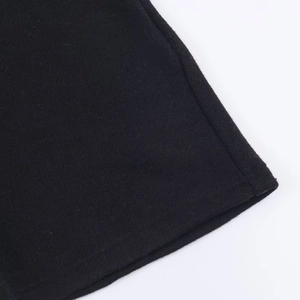 Nahaufnahme der schwarzen Strickbaumwoll-Textur am Saum eines kurzen Kleides
