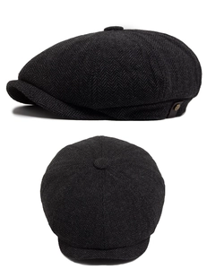 Detail of herringbone wool fabric and side button on a classic British newsboy cap