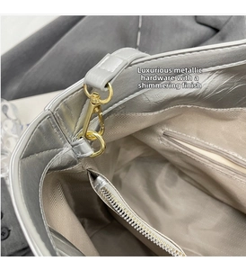 Detailed macro view of silver metallic leather tote lining and gold snap hook closure