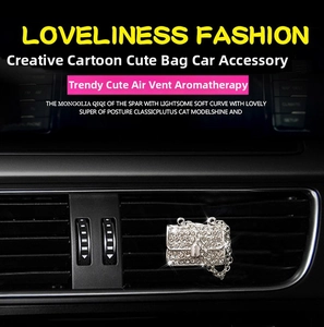 Close-up of diamond-studded bag-shaped car air vent perfume clip with silver chain