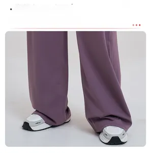 Détail du pantalon large lilas montrant le tissu drapé et la taille croisée élégante